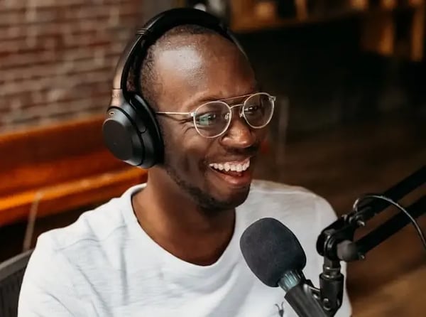 Young adult male recording himself on microphone.